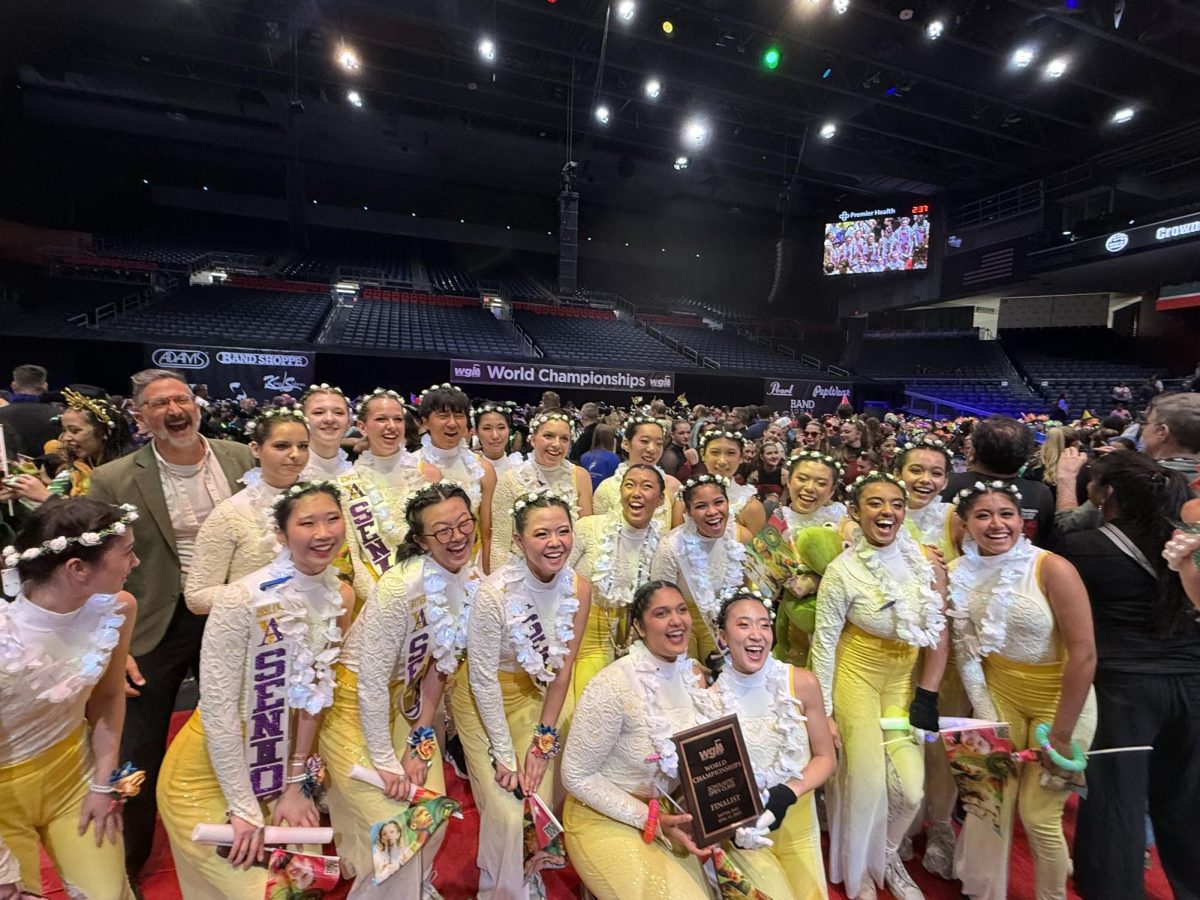 Amador Valley's Varsity Winter Guard holding their medal screaming, "Dayton!" while taking pictures at Awards. 